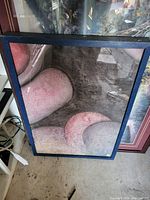 Photo of a framed modern abstract art print with pink and gray shapes.