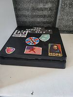 Black Playstation 4 console with multiple stickers on top surface.