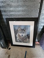 Image of framed wolf picture leaning against wall, showing full artwork, frame, and mat board.