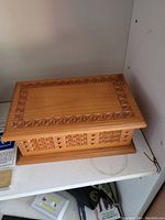 Carved wooden box closed showing intricate geometric star patterns on top and sides.