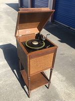 Full view of Edison Disc Phonograph in wooden cabinet with lid open, showing player and speaker grill on front.
