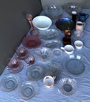Lot overview showing mixed glass and pottery items arranged on fabric.
