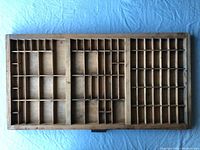 Top-down view of full wooden tray showing many compartments of varying sizes across the tray surface.