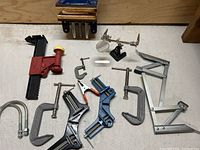 Overview of various clamps including C-clamps, screw clamps, a helping hands tool, and a corner clamp