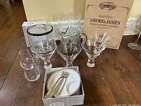 Photo showing full set of items including glassware, wooden box, pitcher, appetizer plates and forks, and ice bucket.