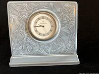 Front view of the Wedgwood ceramic clock showing the clock face with Roman numerals and embossed decorative pattern.