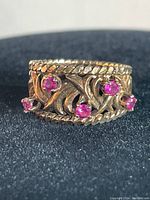 Front view showing three purple stones and filigree motif