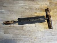Photo showing the full length of the antique woodworking tool with cast iron blade and wooden handles on a wood surface.