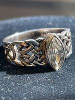 Close-up front view of the sterling silver ring showing the clear marquise cut stone and Celtic knot design.