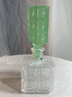 Front view showing the clear glass perfume bottle and green jadeite stopper upright.