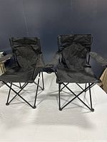 Two black Ozark Trail deluxe camping chairs front view, showing seats and armrests.