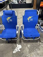 Two blue Tommy Bahama backpack chairs side by side showing full front view, including seat, armrests, and cooler pouches.