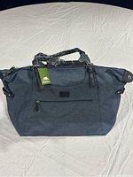 Front view of large blue Roots duffel bag with zippered front pocket and wrapped handles