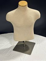 Front view of white half mannequin torso on metallic square base