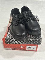 Front view of the black leather men's shoes on original box showing overall condition and appearance