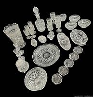 Crystal set displayed from above on black background showing all items in the set with intricate cut patterns and sparkling clarity.