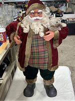 Front view of the vintage Santa Claus figurine showing detailed face, clothing, and teddy bear in arm.