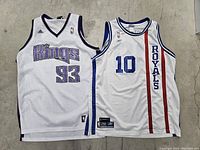 Two vintage basketball jerseys laid on concrete floor: Sacramento Kings and Kansas City Royals