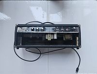 Top-down view of tube amp head showing front control panel with two input jacks, three control knobs and visible internal tubes