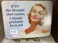 Photo of entire reproduction tin sign showing woman and humorous quote text.