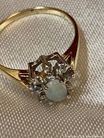 Front view of ring on cloth background showing center stone and accent stones