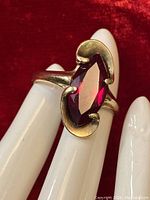 Front angle of ring showing marquise-cut red stone in 10K yellow gold setting