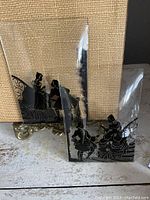 Side view of both beveled glass panels showing hand painted black silhouette figures and beveled edges