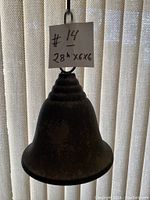Close-up image showing the vintage metal bell with hanging loop and attached chain, indicating the overall size of approximately 11 inches in height including chain.