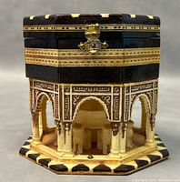 Front angled view showing the carved lion figures and fountain inside the open base, as well as carved arches and columns.