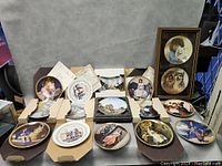 Wide view of all plates displayed on surface showing various Norman Rockwell style scenes and frames.