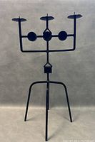 Front view of large black iron Scandinavian candelabra with tripod base and three candle holders.