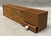 Angled view showing wood grain, cork detail, and drawer knob