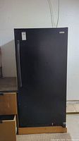 Front view of the black Kenmore standing freezer, showing the vertical door handle and overall upright shape.