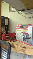 Shelf showing the boxed 1" brad air nailer and metal table vice.