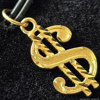 Close-up front view of the pendant showing details of the dollar sign shape and texture.