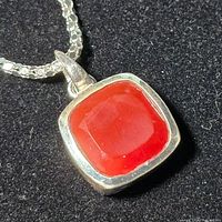 Close-up of the red agate pendant in sterling silver setting on chain.