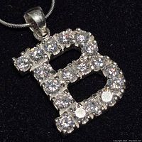 Close-up of the sterling silver 'B' pendant encrusted with cubic zirconia stones showing detail and sparkle.