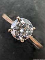 Top view of the solitaire ring showing the round diamond and four-prong setting on yellow gold band