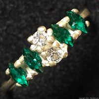 Close-up of the ring showing the green and clear stones set in sterling silver.