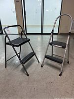 Both folding stepstools side by side showing size and shape differences.