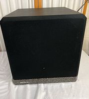 Front view of Velodyne F-1200-B subwoofer with black fabric grille and granite-style base.
