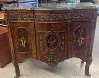 Front view of vintage buffet table showing marble top, marquetry doors and brass ornamentation