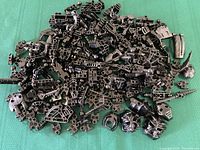 Pile of assorted black Lego Bionicle parts showing the variety of body pieces, connectors, and limbs.