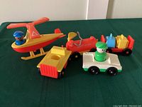 Shows entire set including helicopter with blue-hatted pilot, fuel truck, luggage cart with green-hatted pilot, tractor with attached flatbed, and two plastic pilot figures.