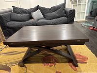 Table in lowered coffee-table position, top closed, showing overall design and base.