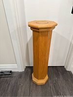 Front view of the full plant stand showing the octagonal shape, light oak wood grain, and overall structure.