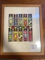 Full view of framed Bacardi limited edition print with variation of Bacardi bottle labels arranged in two rows.