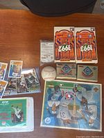 Various baseball cards, raw baseball, and unopened sealed pack boxes displayed on a wooden table