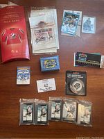 Spread of all hockey cards, packs, mini jersey card, and miscellaneous stickers on a wooden surface.