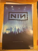 Photo of Nine Inch Nails Beside You In Time print with visible logo, figure, and abstract background.